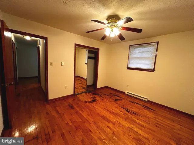 a view of an empty room with wooden floor