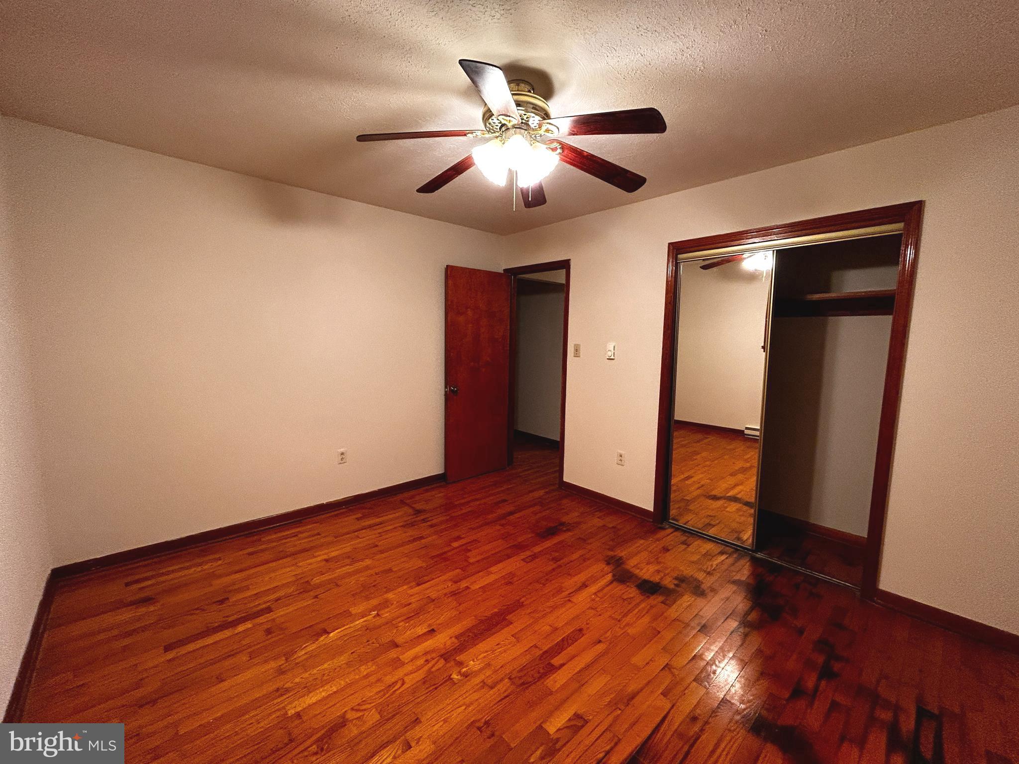 760 Jordan Springs Road Stephenson, VA 22656 - Photo 17 of 27 a view of an empty room with wooden floor and a ceiling fan