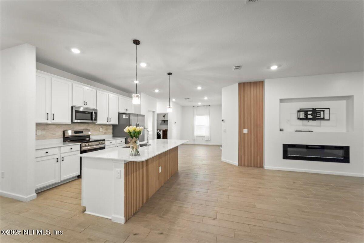 1598 Lachlan Circle Jacksonville, FL 32218 - Photo 7 of 38 a large white kitchen with stainless steel appliances kitchen island granite countertop a refrigerator and a stove top oven