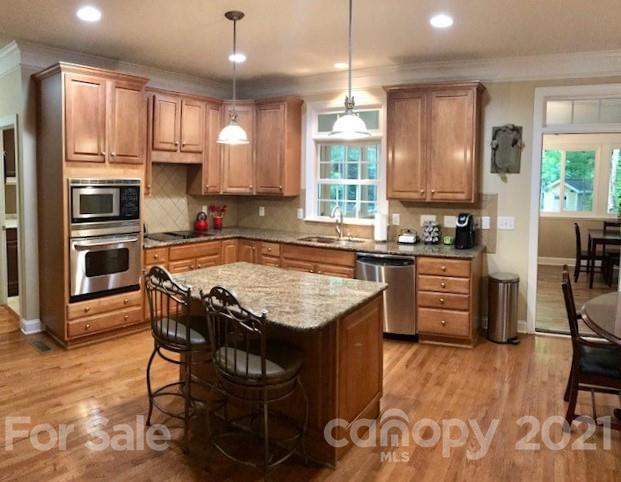 1912 Riverbank Road Waxhaw, NC 28173 - Photo 6 of 19 a kitchen with granite countertop kitchen island stainless steel appliances a stove a sink a counter top space cabinets and furniture