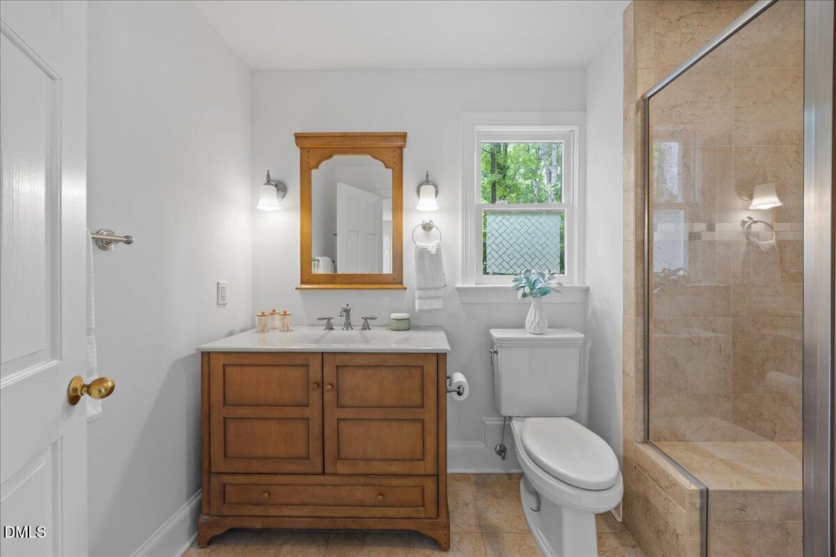 6516 Bakersfield Drive Raleigh, NC 27606 - Photo 35 of 59 a bathroom with a toilet a sink and mirror