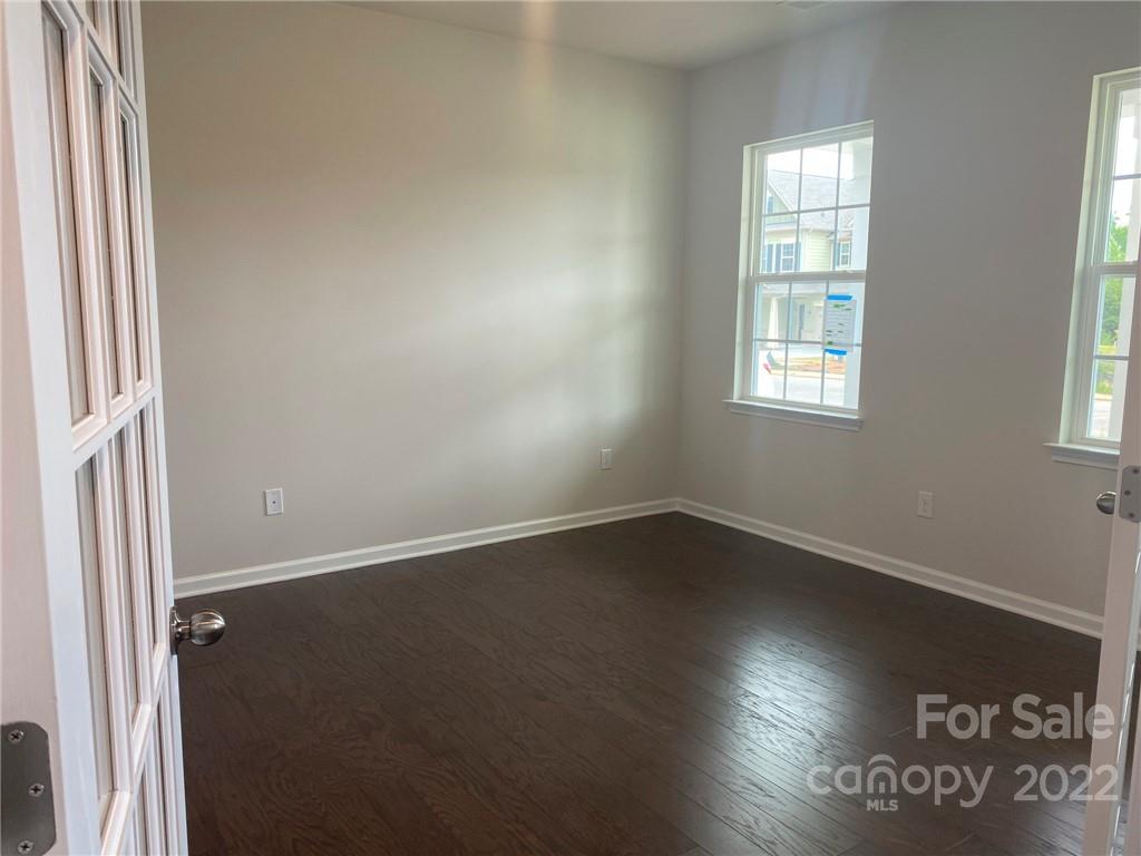 4043 Oakmere Road, Unit 953 Waxhaw, NC 28173 - Photo 4 of 21 an empty room with wooden floor and windows
