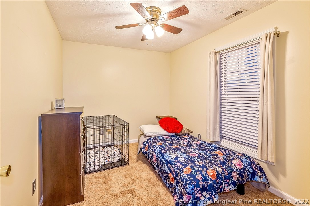 370 Sawyer Road Cameron, NC 28326 - Photo 14 of 26 a bedroom with a bed and a chandelier