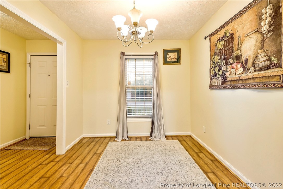 370 Sawyer Road Cameron, NC 28326 - Photo 20 of 26 a view of a bedroom with wooden floor and a chandelier