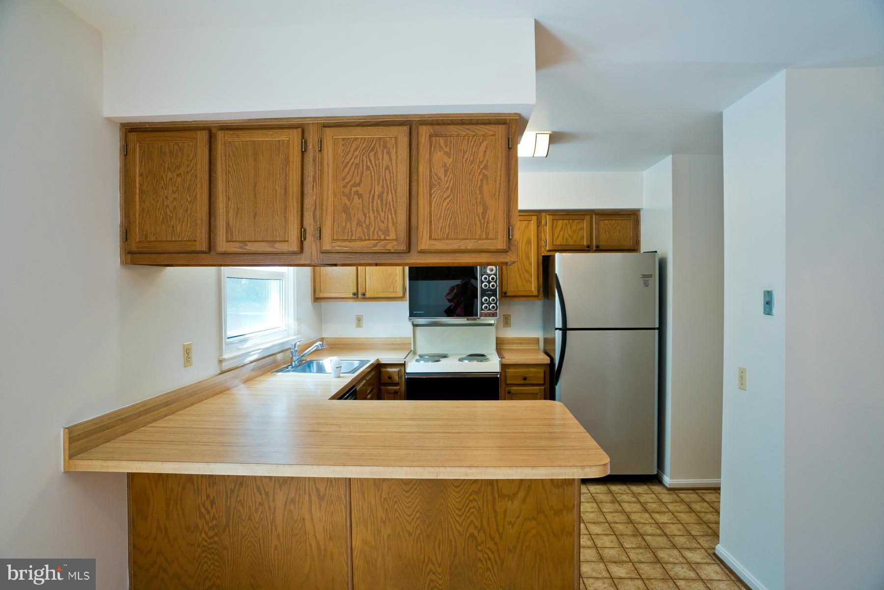 325 Crescendo Way Silver Spring, MD 20901 - Photo 14 of 21 a kitchen with a sink a stove and refrigerator