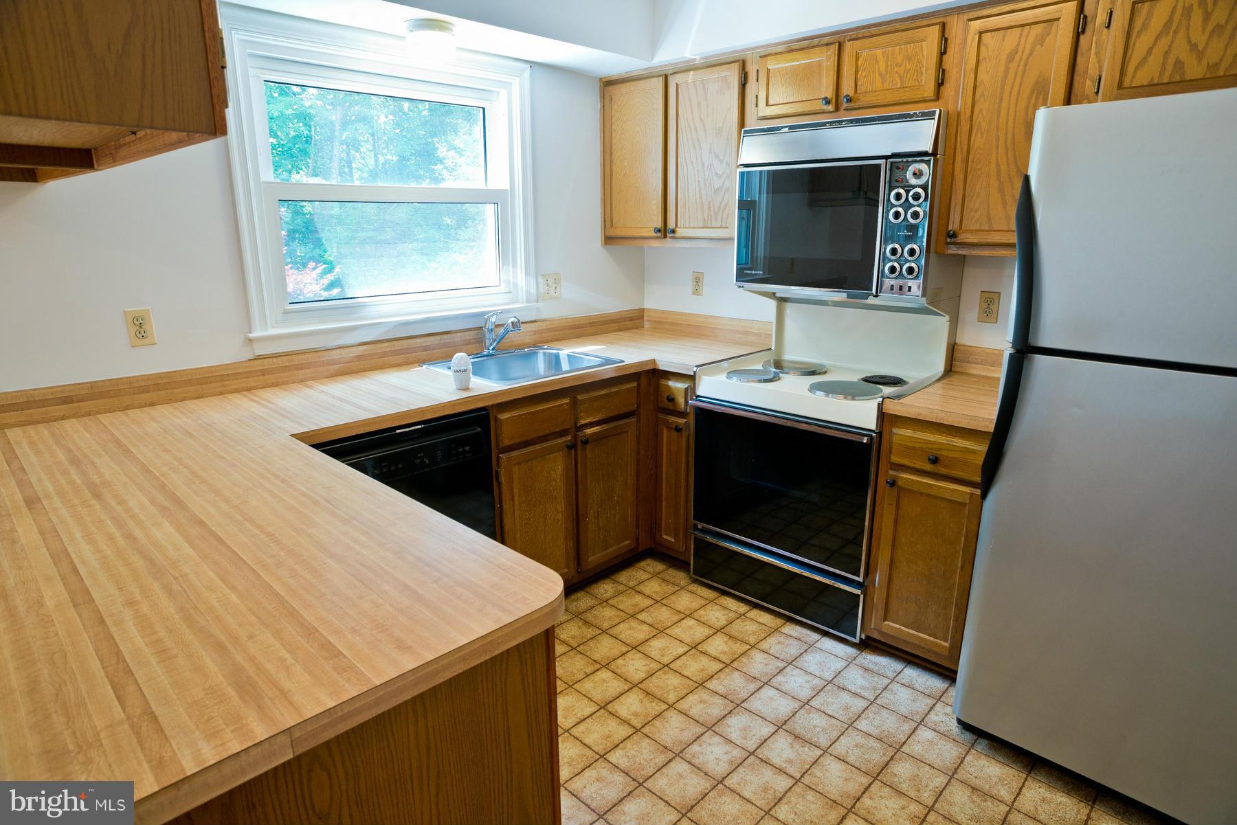 325 Crescendo Way Silver Spring, MD 20901 - Photo 16 of 21 a kitchen with stainless steel appliances granite countertop a sink stove and refrigerator