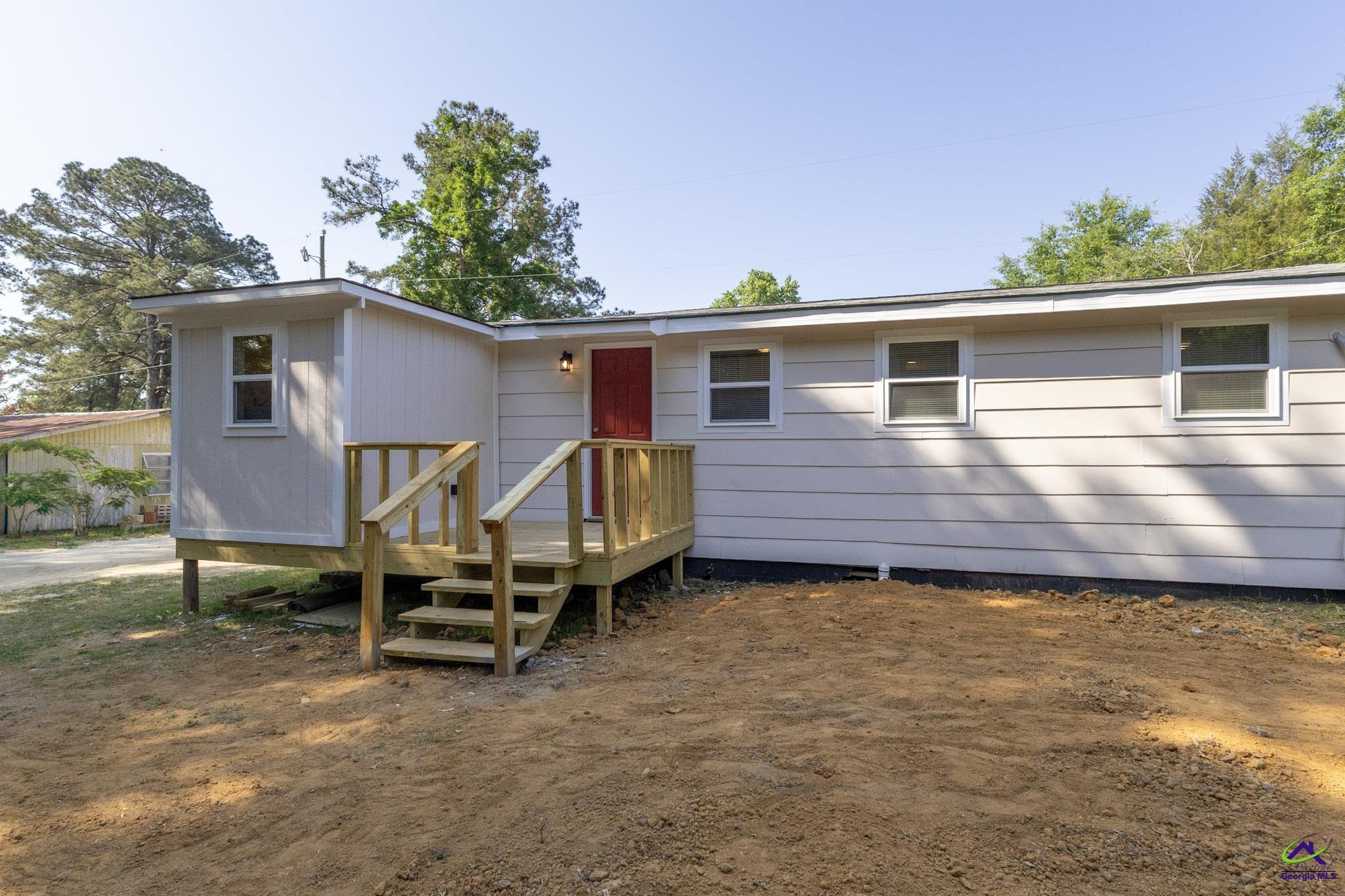 156 Churchwell Road Cochran, GA 31014 - Photo 20 of 20 a view of a house with wooden deck and a yard