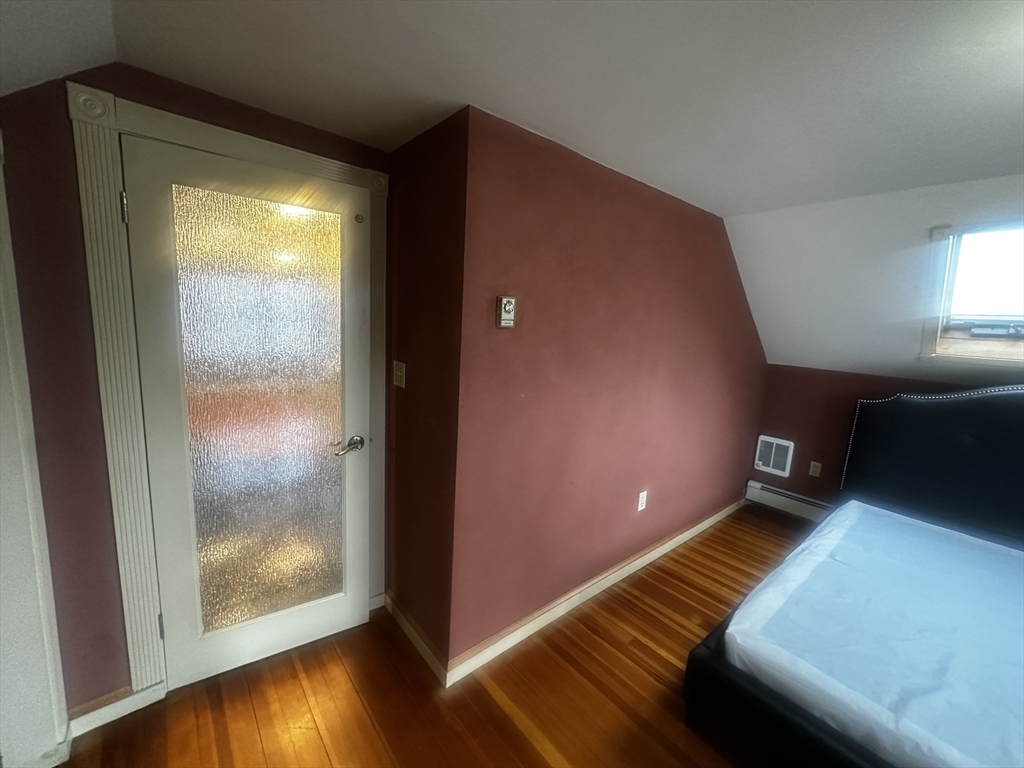 1034 North Main Street, Unit 2 Randolph, MA 02368 - Photo 6 of 14 a view of an empty room with wooden floor and windows