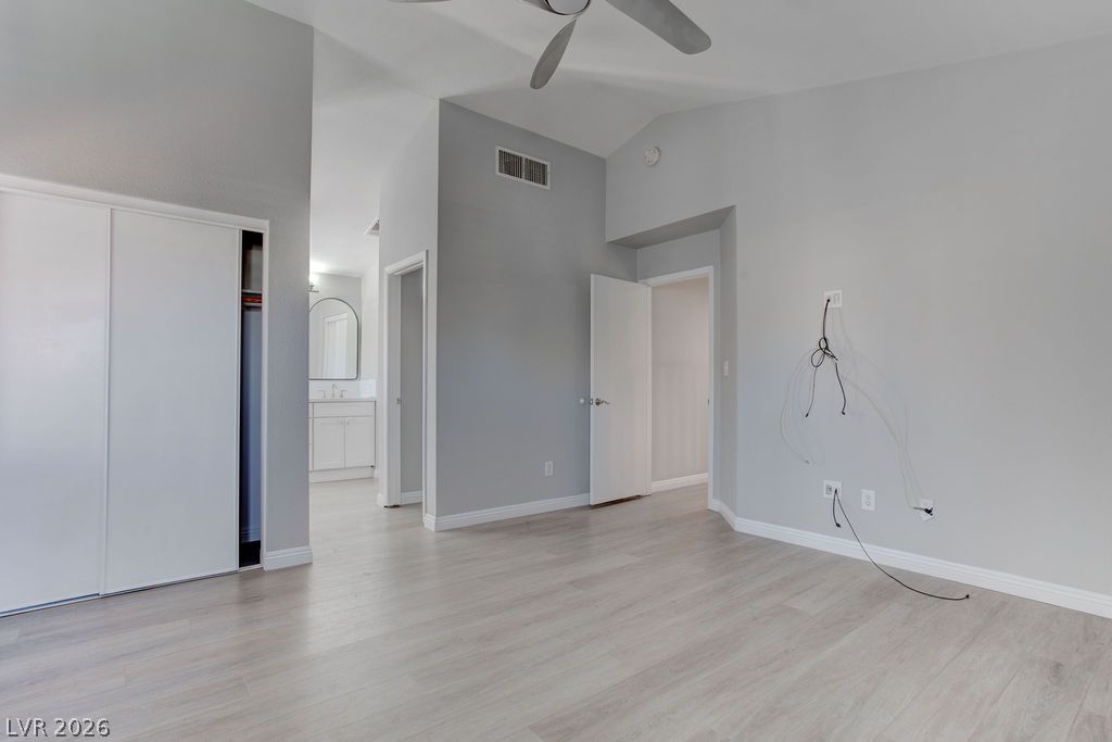 1416 Walstone Road North Las Vegas, NV 89031 - Photo 35 of 47 A spacious bedroom features vaulted ceilings and light wood-look flooring.