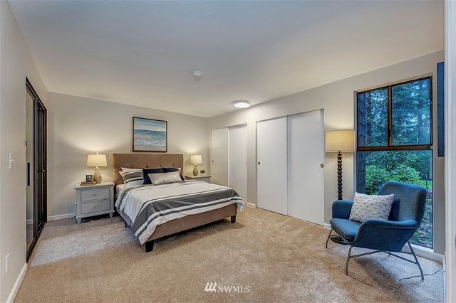 a spacious bedroom with a bed a couch and a window