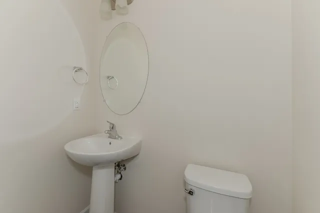 a bathroom with a sink a toilet and mirror
