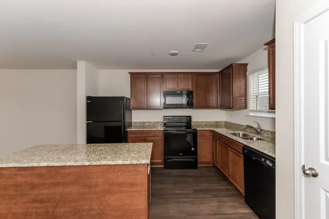 a kitchen with stainless steel appliances granite countertop a stove a sink and a refrigerator