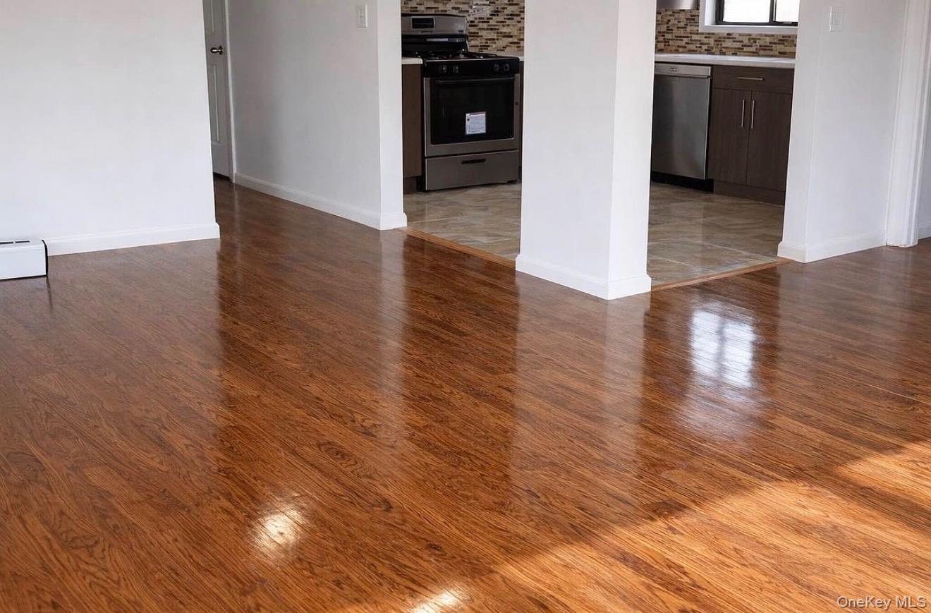 235-15 Bentley Road Queens, NY 11422 - Photo 14 of 17 a view of an empty room with wooden floor