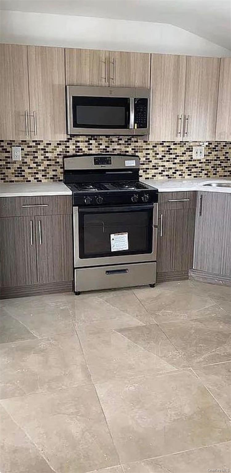 235-15 Bentley Road Queens, NY 11422 - Photo 15 of 17 a kitchen with a stove and a microwave