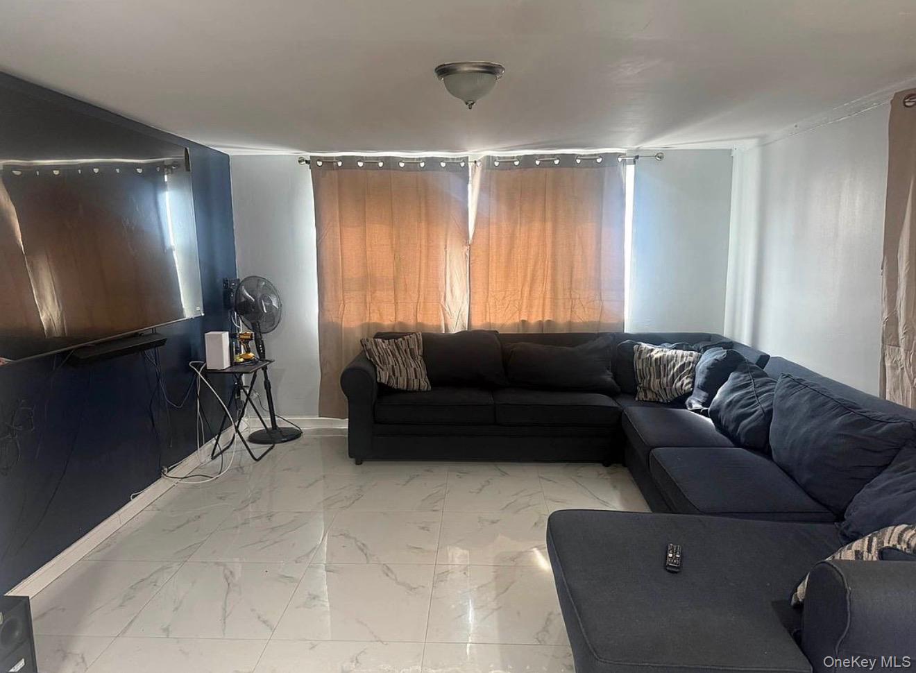 235-15 Bentley Road Queens, NY 11422 - Photo 9 of 17 a living room with furniture and a flat screen tv