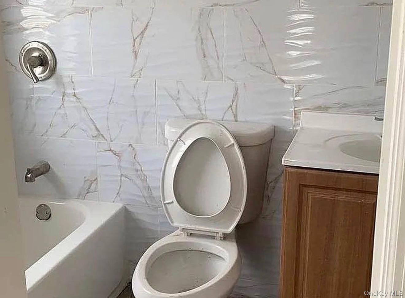 235-15 Bentley Road Queens, NY 11422 - Photo 10 of 17 a bathroom with a sink a toilet and bathtub