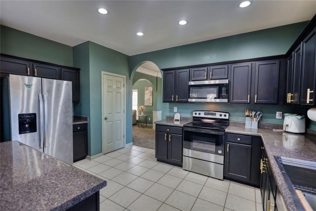 25 Caseys Way Covington, GA 30014 - Photo 14 of 33 a kitchen with stainless steel appliances granite countertop a refrigerator a stove top oven a sink and dishwasher