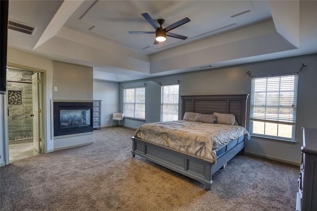 25 Caseys Way Covington, GA 30014 - Photo 23 of 33 a spacious bedroom with a bed and a fireplace