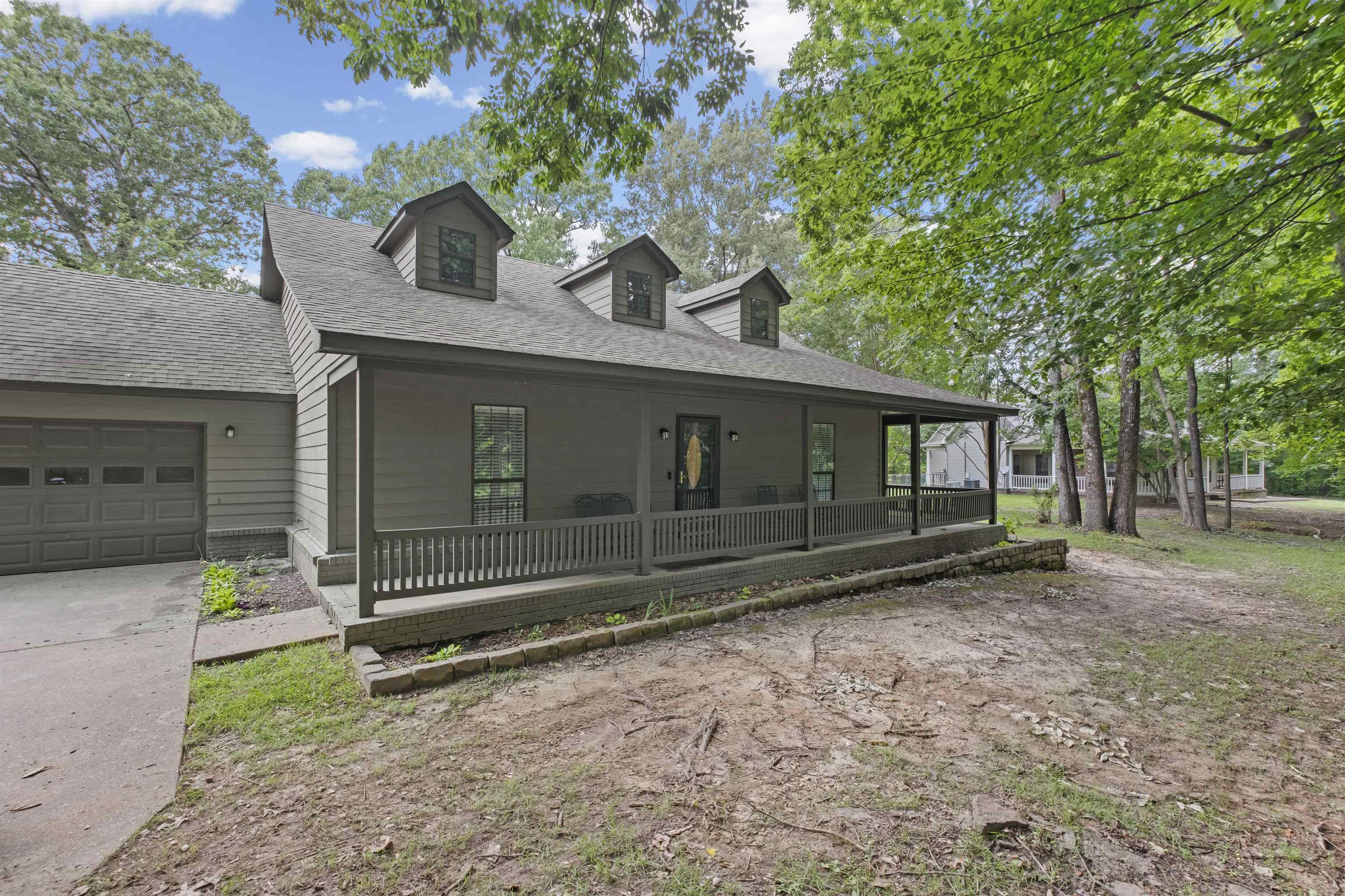 Craftsman-style facade with a covered front porch, three dormer windows, and a two-car garage