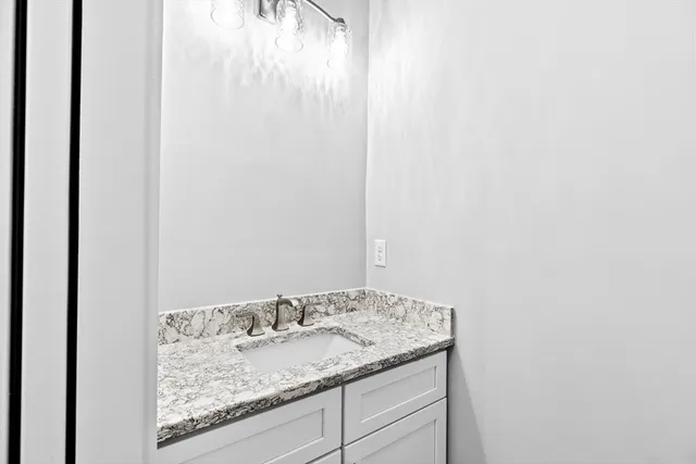 a bathroom with a granite countertop sink and vanity