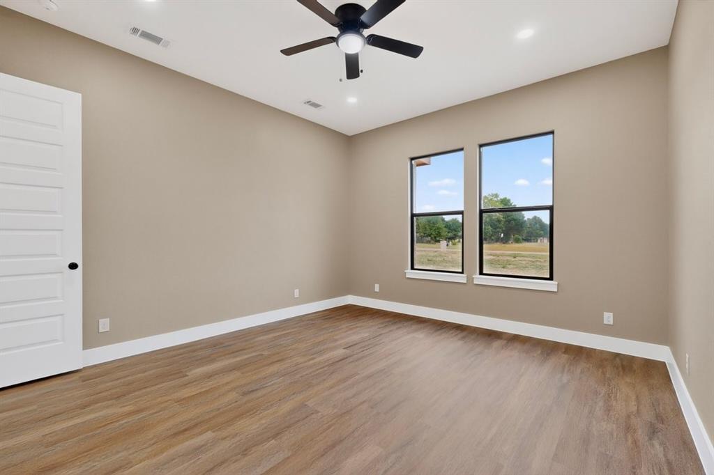 4737 Pine Ridge Court Athens, TX 75752 - Photo 16 of 26 an empty room with wooden floor chandelier fan and windows