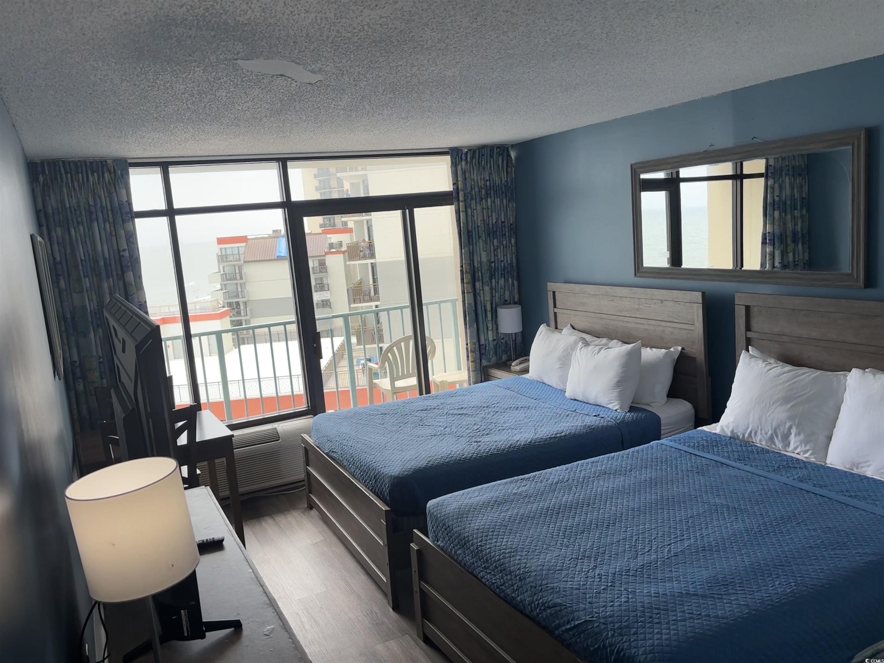 201N 74th Avenue North, Unit 2845/46 Myrtle Beach, SC 29572 - Photo 8 of 9 Bedroom with multiple windows, wood finished floors, a textured ceiling, access to outside, and a wall of windows