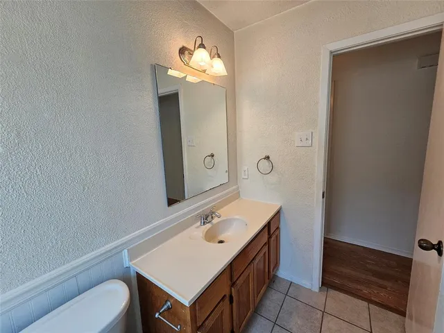 a bathroom with a sink a light fixture and a toilet