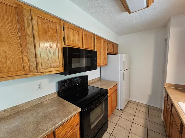 a kitchen with stainless steel appliances a stove a microwave a sink and cabinets