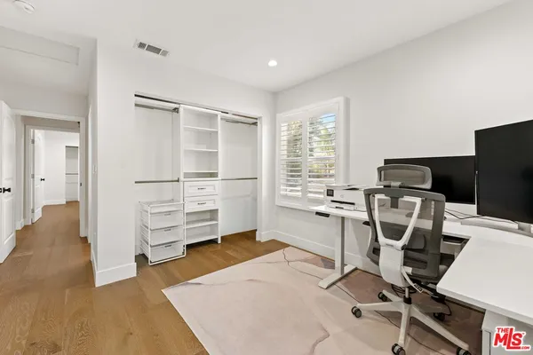a view of a workspace with furniture and a window