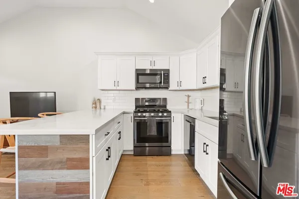 a kitchen with stainless steel appliances a refrigerator sink and stove