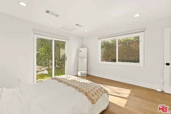 a bed sitting in a bedroom next to a window