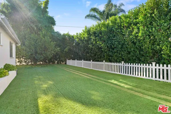 a view of a green field with wooden fence