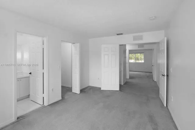 an empty room with windows and bathroom