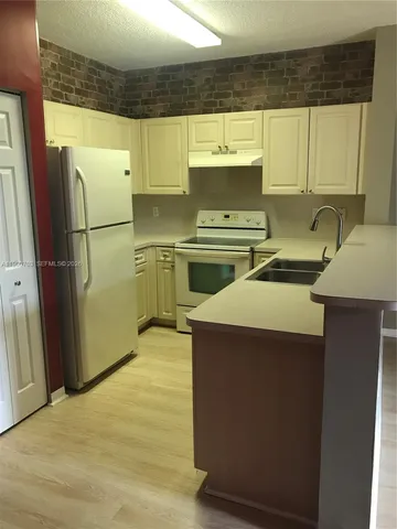 a kitchen with a sink stove and refrigerator