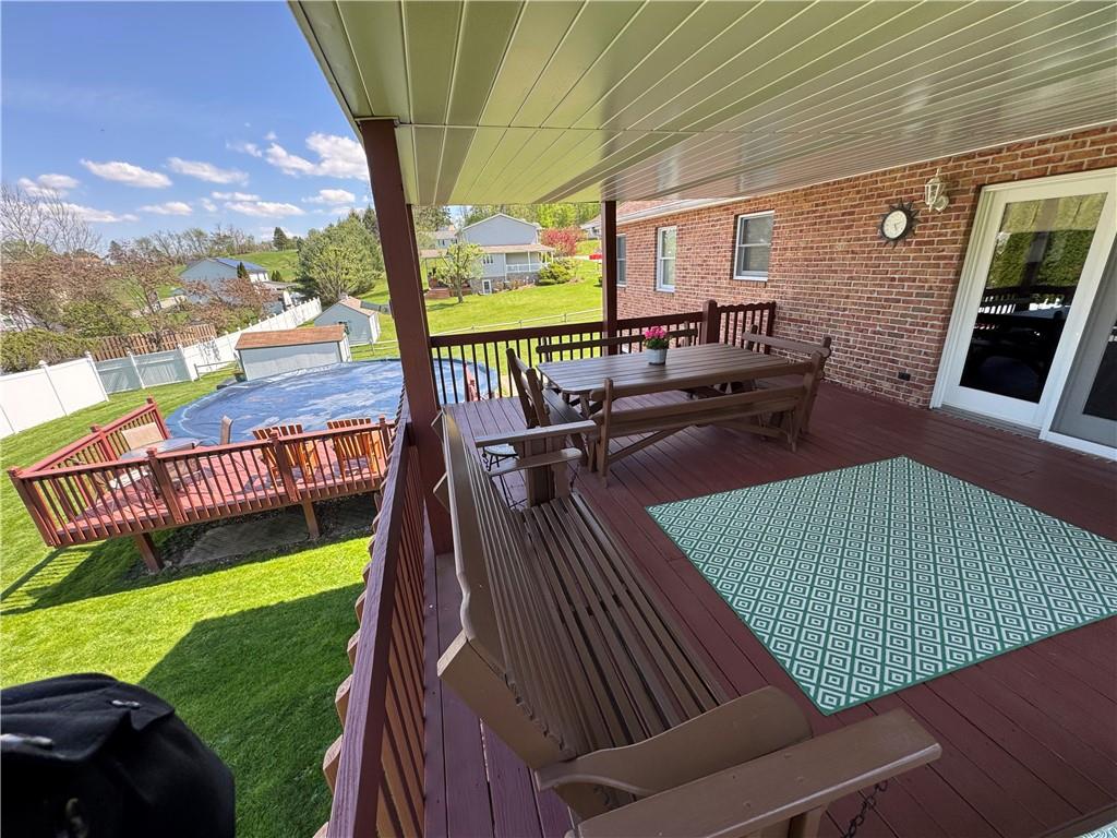 208 Pats Drive Rostraver Township, PA 15012 - Photo 42 of 50 a view of a patio with table and chairs potted plants with wooden floor and fence