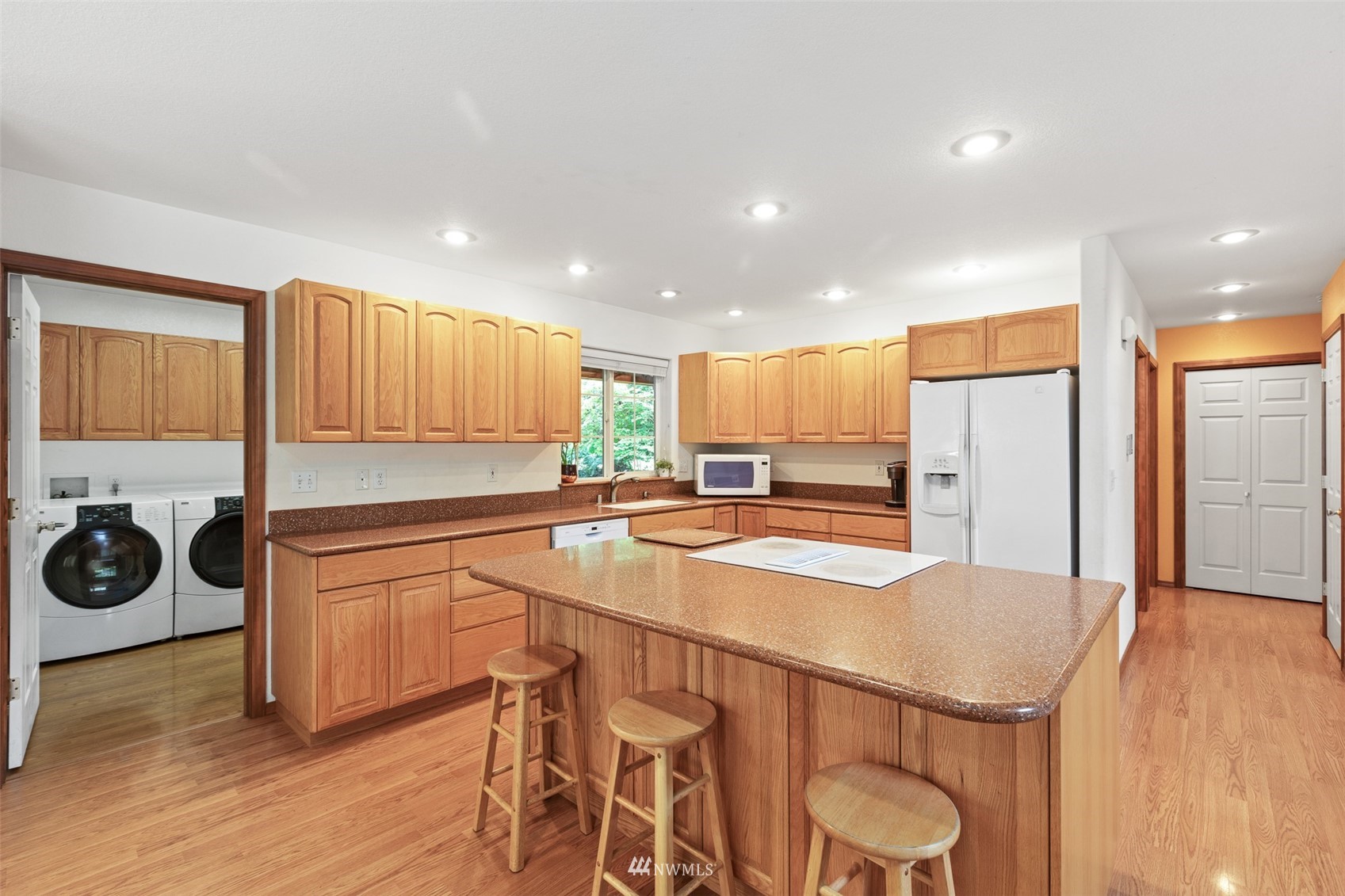 257 Riverside Road Sequim, WA 98382 - Photo 7 of 40 a kitchen with stainless steel appliances granite countertop a sink a stove a refrigerator and cabinets with wooden floor