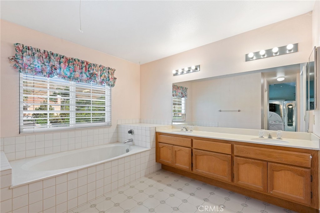3047 Prado Lane Colton, CA 92324 - Photo 29 of 51 a spacious bathroom with double vanity a large mirror a bathtub and a shower
