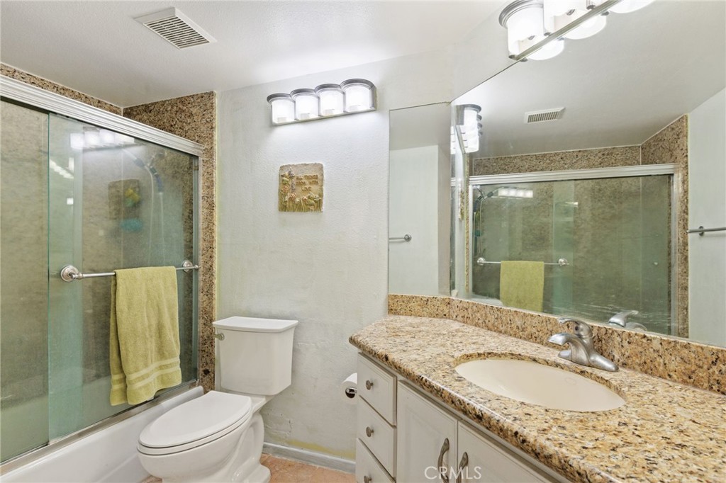 3047 Prado Lane Colton, CA 92324 - Photo 31 of 51 a bathroom with a granite countertop sink toilet a mirror and shower