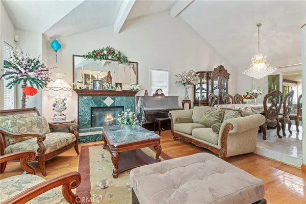a living room with furniture a fireplace and a chandelier
