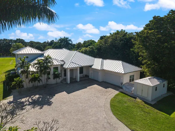 a front view of a house with swimming pool having outdoor seating