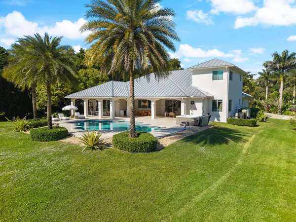 an aerial view of a house with a yard and trees