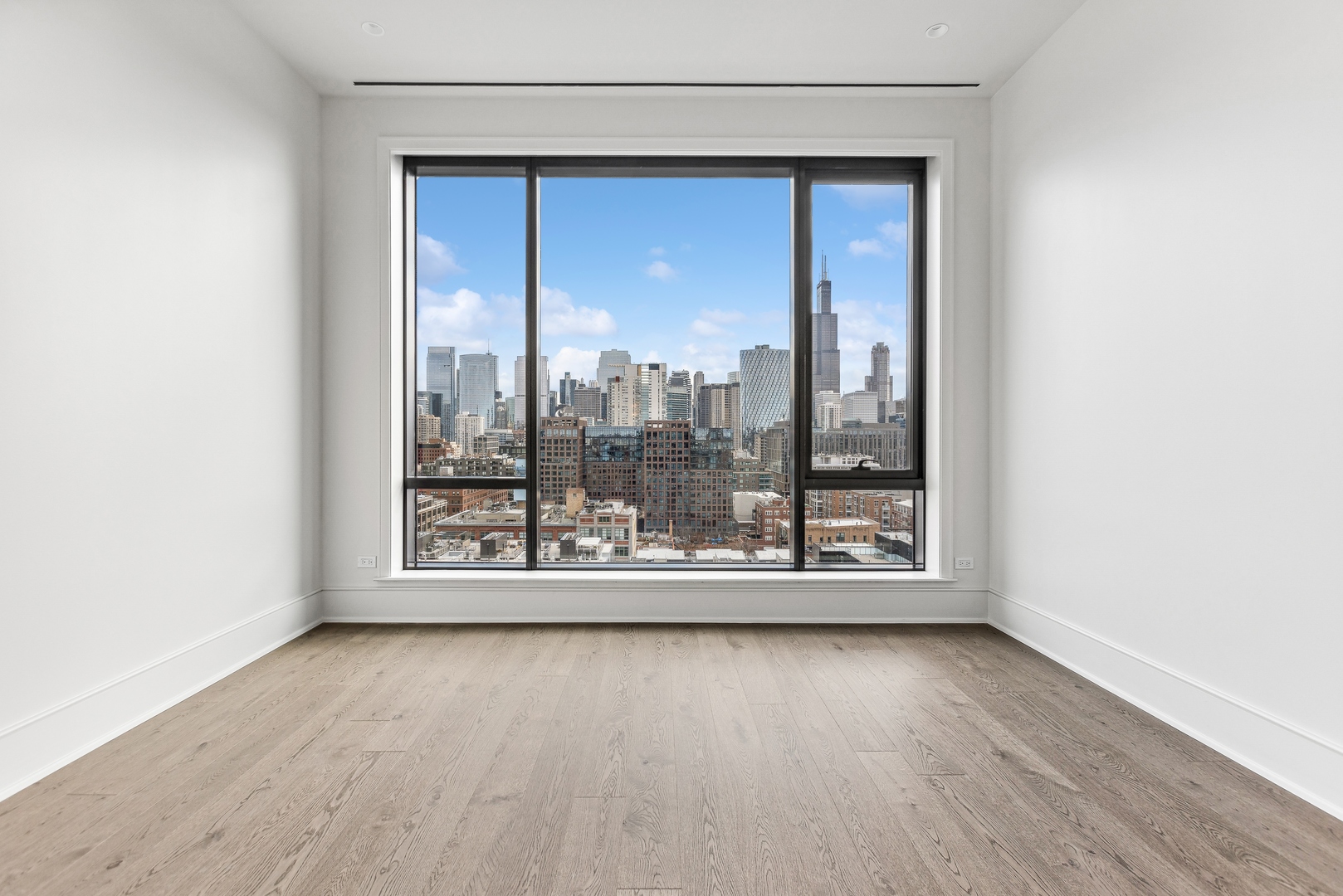 21 North May Street, Unit 1402 Chicago, IL 60607 - Photo 29 of 49 a view of an empty room with wooden floor and a window