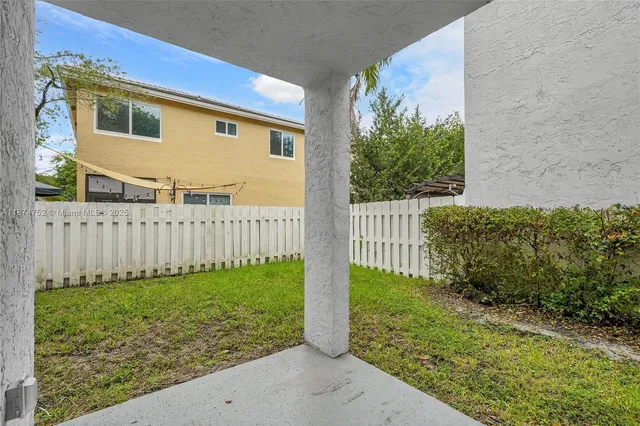 a view of a house with wooden fence and a yard