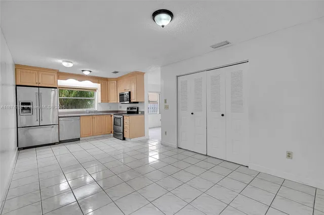 a kitchen with stainless steel appliances granite countertop a refrigerator and a sink