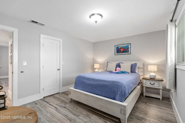 a bedroom with a bed and wooden floor