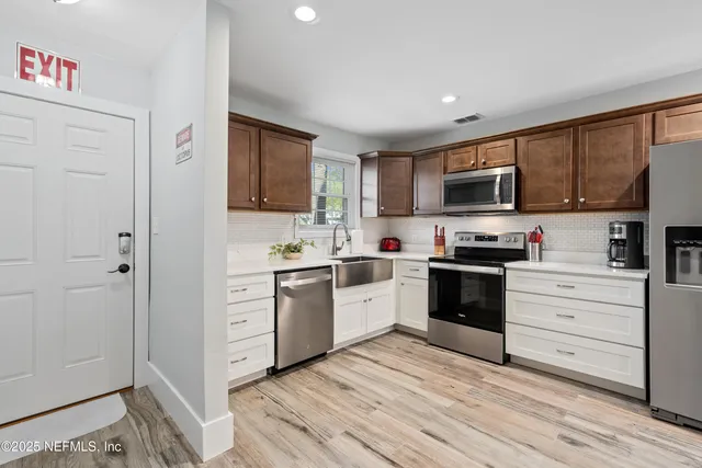 a kitchen with cabinets stainless steel appliances and a window