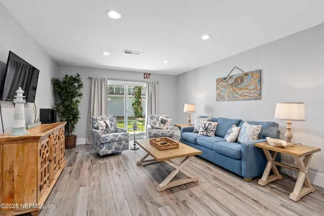 a living room with furniture a flat screen tv and a large window
