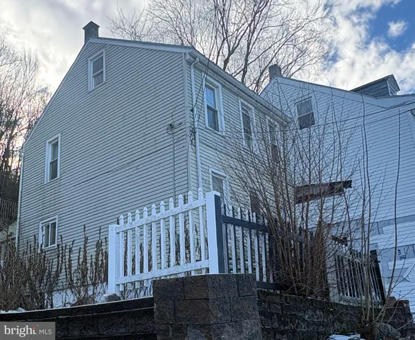 a view of a house with a small yard and wooden fence