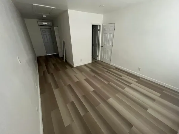 a view of empty room with wooden floor