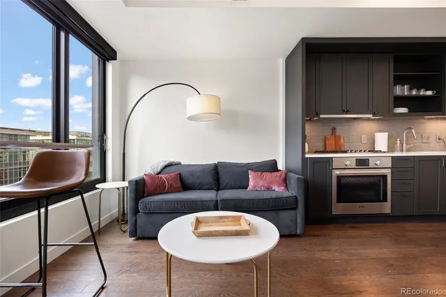 a living room with furniture a flat screen tv and kitchen view